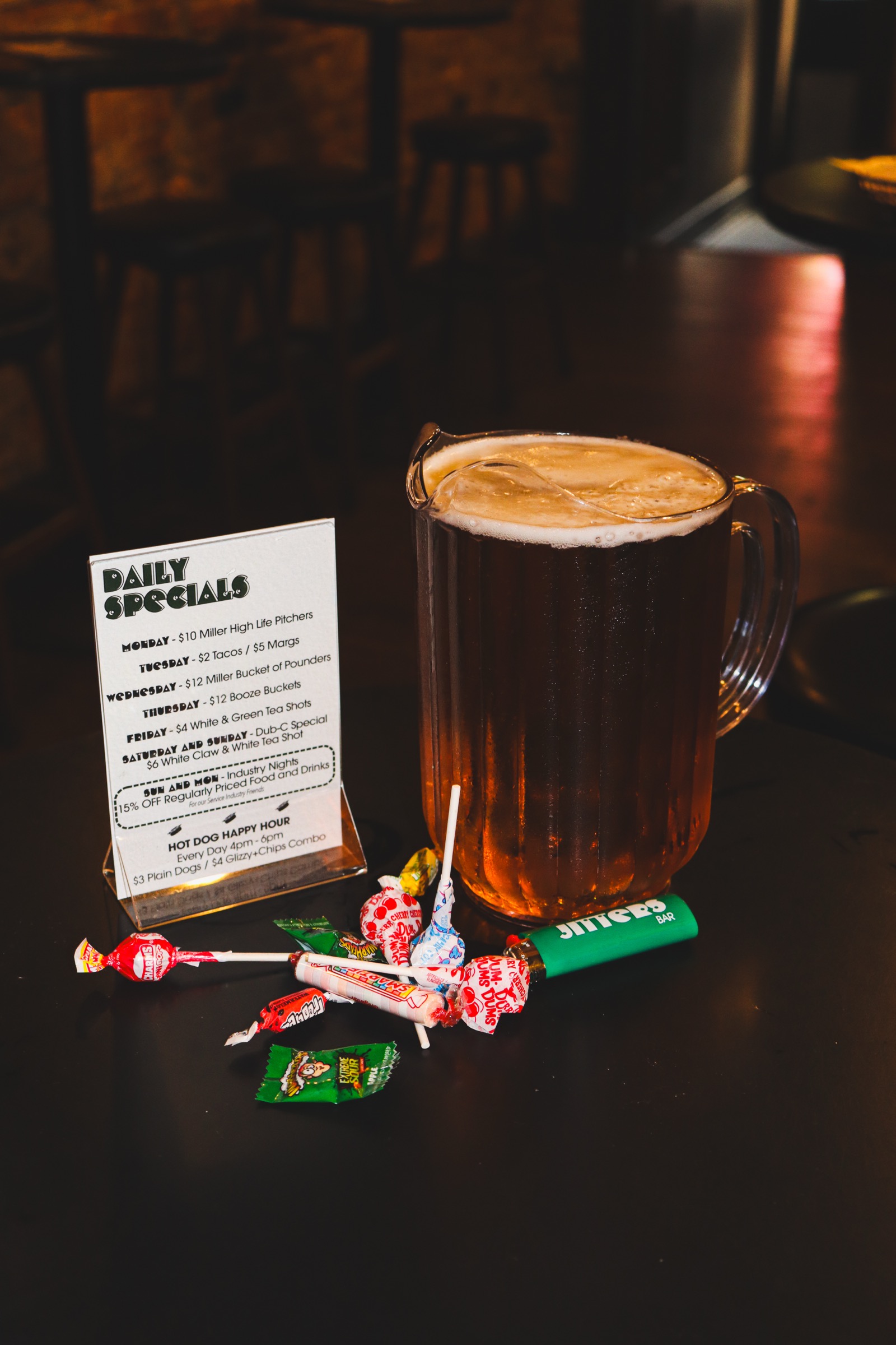 Pitcher of beer next to a pile of lollipops at Jitters